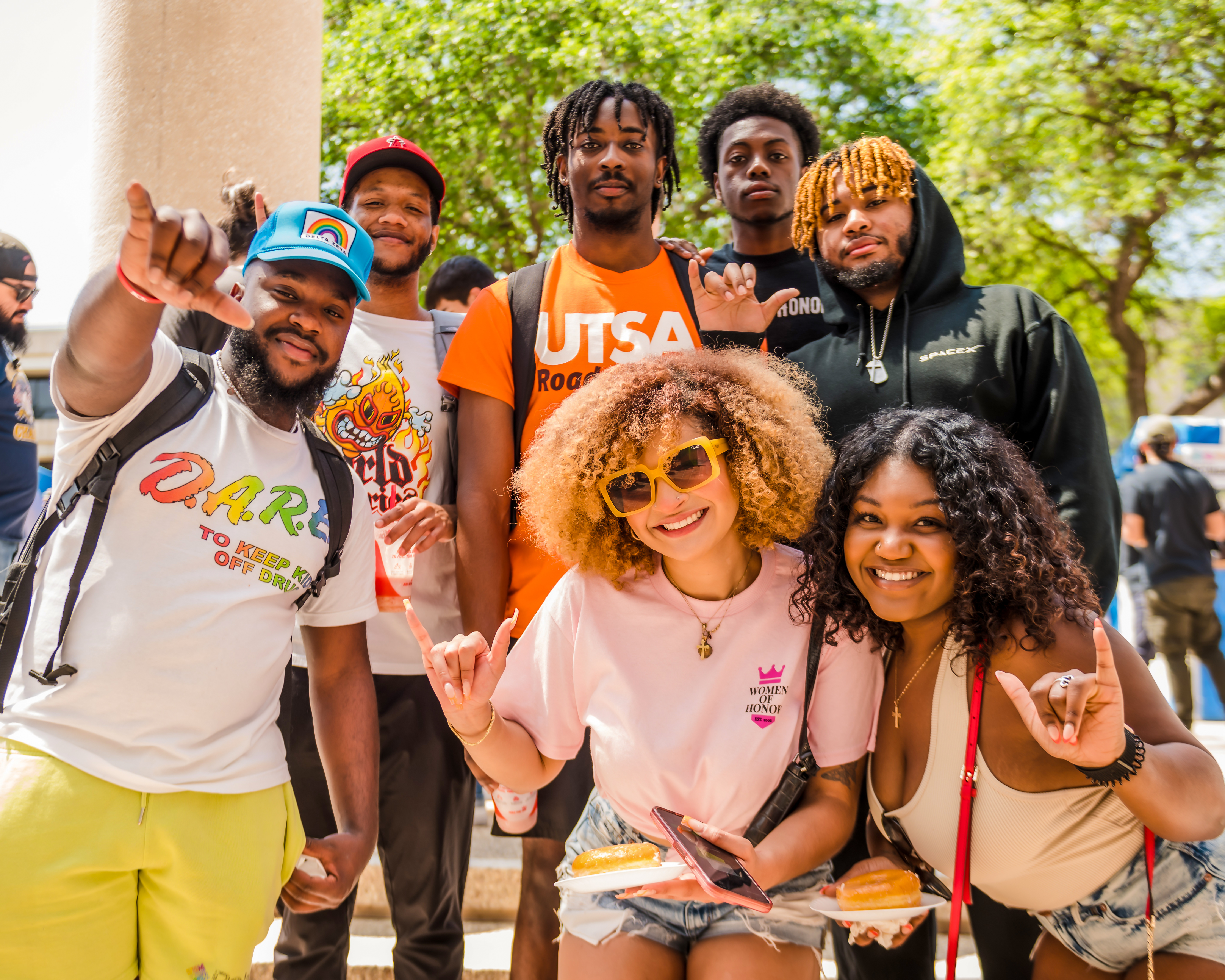 Groupd of UTSA students holding the "UTSA Birds Up" hand gesture.